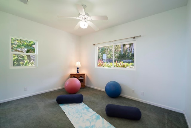 workout room featuring dark colored carpet and ceiling fan