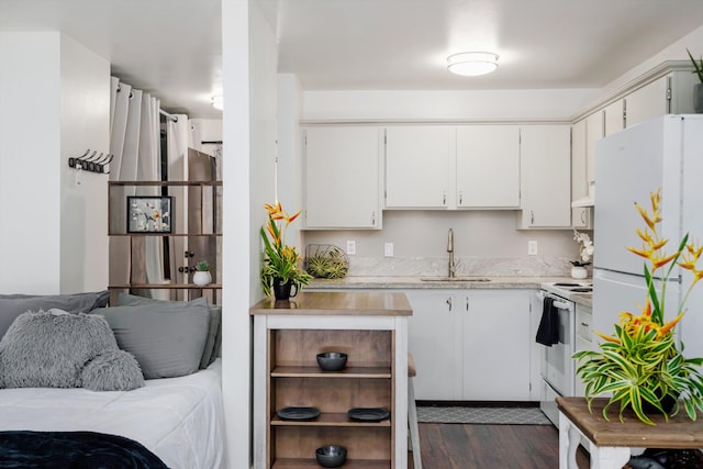 kitchen with white cabinets, white appliances, dark hardwood / wood-style floors, and sink