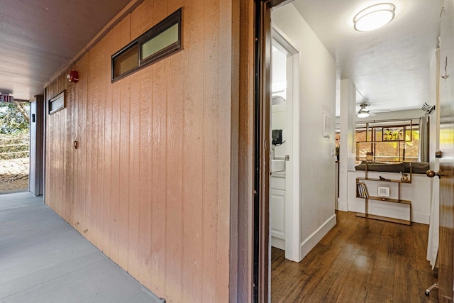 hall with wood-type flooring and wooden walls