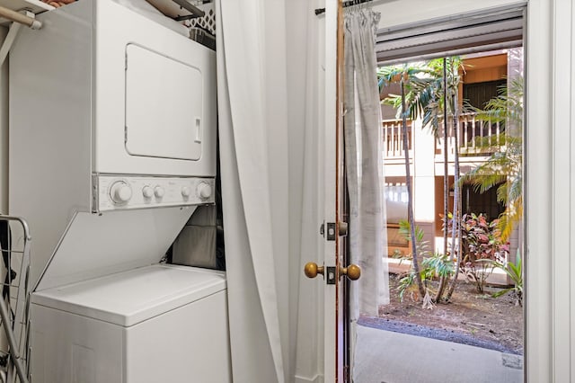 clothes washing area featuring stacked washer and clothes dryer