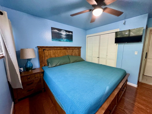 bedroom featuring ceiling fan, a closet, and dark wood-type flooring