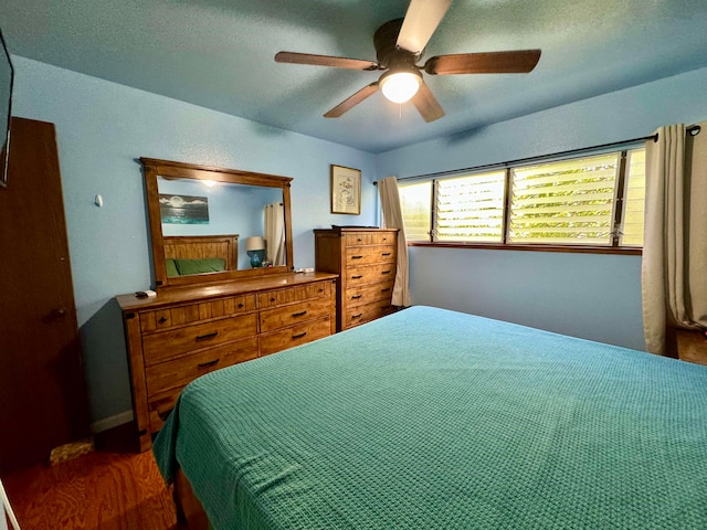 bedroom with ceiling fan and dark hardwood / wood-style flooring