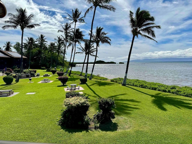 view of property's community with a water view and a yard