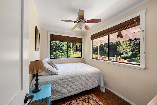 bedroom with ceiling fan, dark parquet floors, and ornamental molding