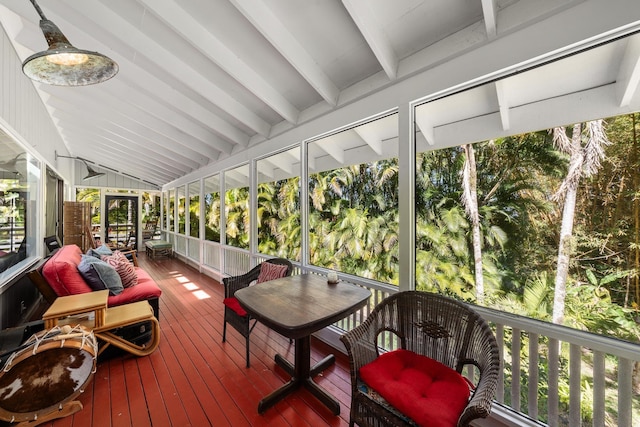 sunroom featuring plenty of natural light and lofted ceiling with beams