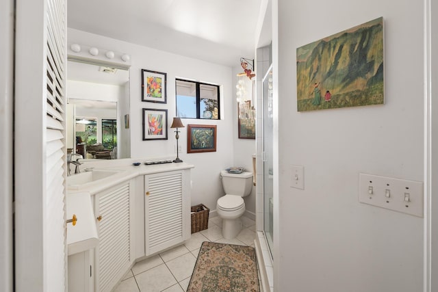 bathroom featuring tile patterned flooring, vanity, toilet, and walk in shower