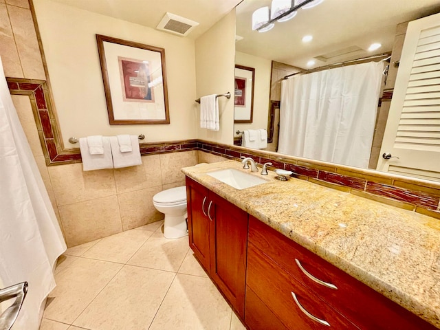 bathroom featuring tile floors, tile walls, toilet, and vanity