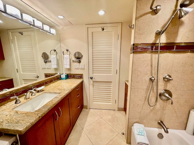 bathroom featuring tile floors, large vanity, and tiled shower / bath