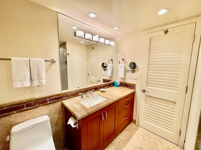 bathroom featuring tile flooring, toilet, and vanity