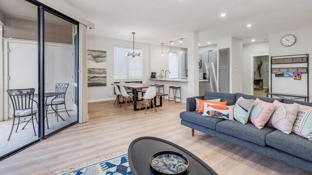 living room with light hardwood / wood-style flooring and a notable chandelier