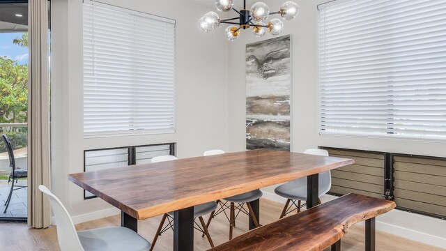 dining area featuring light hardwood / wood-style floors and an inviting chandelier