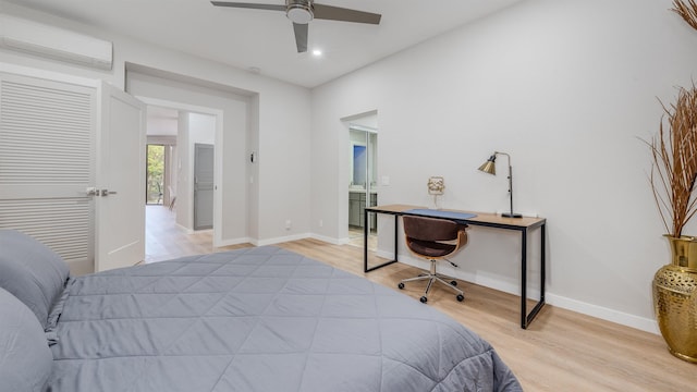 bedroom with light wood-type flooring, a closet, an AC wall unit, and ceiling fan