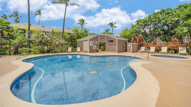 view of swimming pool with a patio and an outbuilding