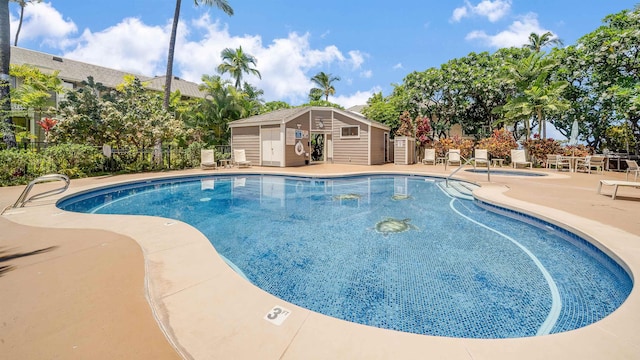 view of swimming pool with a patio area and an outdoor structure