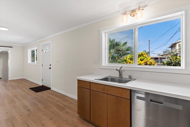 kitchen with sink, light wood-type flooring, dishwasher, and crown molding