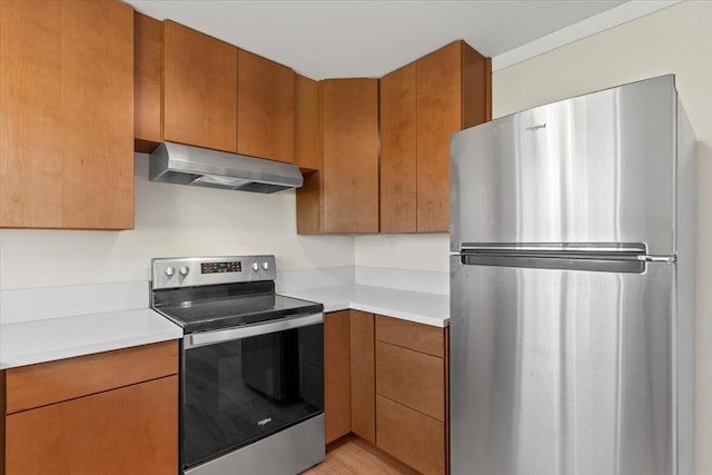 kitchen with light wood-type flooring, extractor fan, and appliances with stainless steel finishes