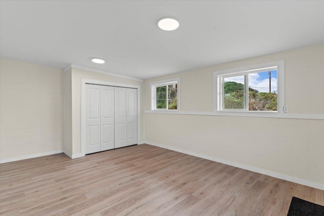 unfurnished bedroom featuring light hardwood / wood-style floors, a closet, and vaulted ceiling