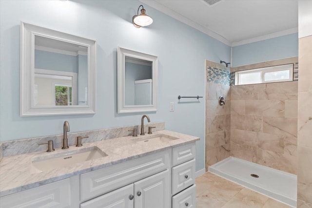 bathroom featuring plenty of natural light, a tile shower, vanity, and ornamental molding