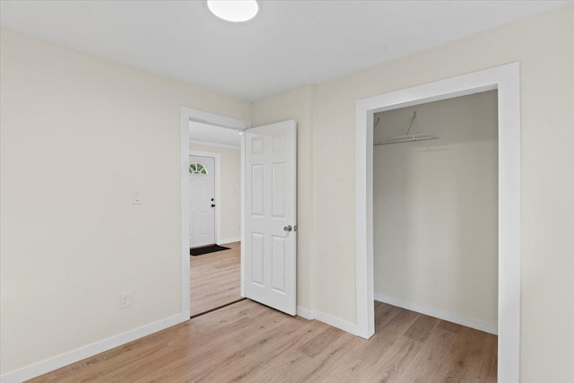 unfurnished bedroom with a closet and light hardwood / wood-style flooring