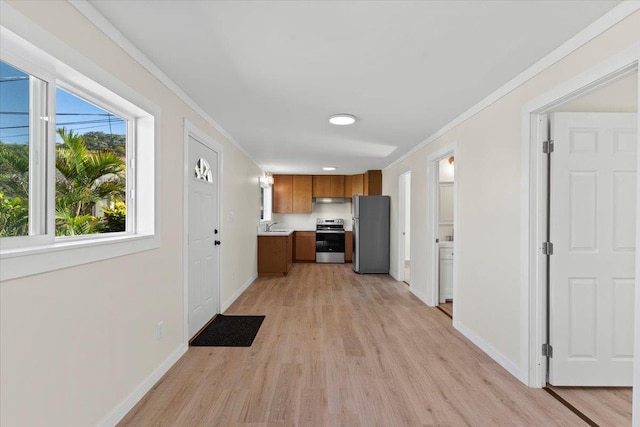 kitchen with sink, ornamental molding, light hardwood / wood-style flooring, and appliances with stainless steel finishes