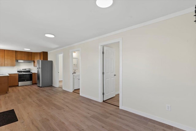 kitchen featuring crown molding, light hardwood / wood-style floors, sink, and stainless steel appliances