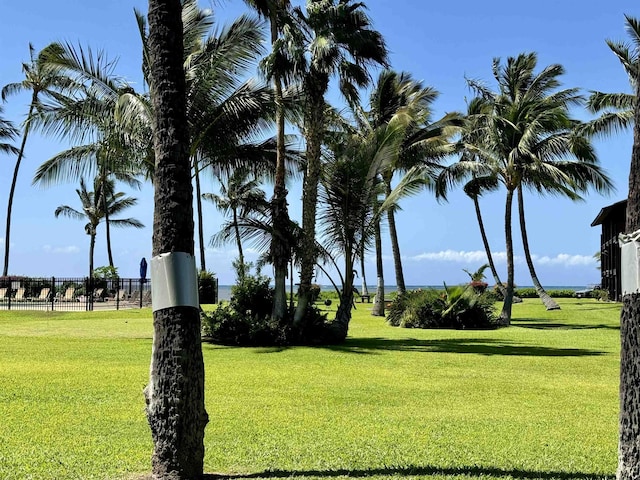 view of property's community with fence and a yard