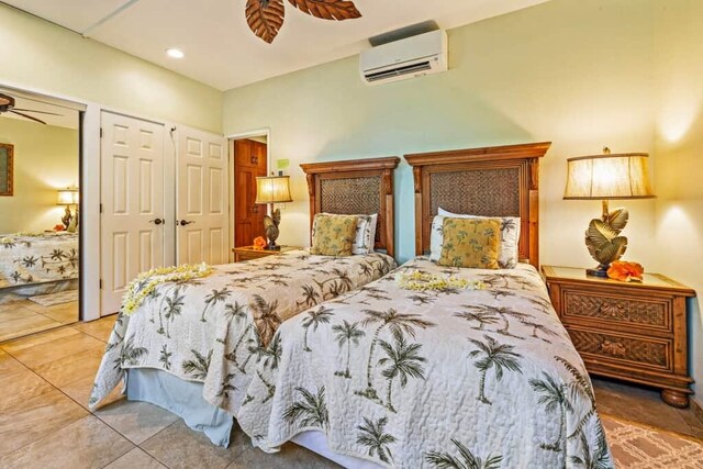 tiled bedroom featuring a wall mounted air conditioner and ceiling fan