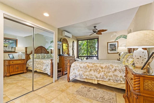 bedroom with an AC wall unit, light tile patterned floors, a closet, and ceiling fan