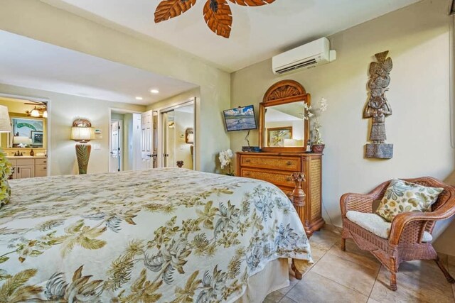 tiled bedroom with ensuite bath, a closet, an AC wall unit, and ceiling fan