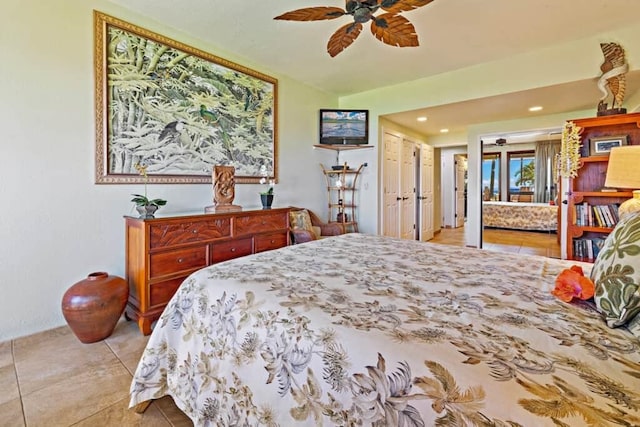 tiled bedroom with ceiling fan and a closet