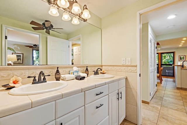 bathroom with tile walls, tile patterned floors, ceiling fan, and vanity