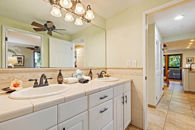 bathroom with tile walls, tile patterned floors, ceiling fan, and vanity