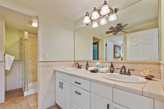 bathroom featuring walk in shower, tile walls, tile patterned floors, vanity, and ceiling fan