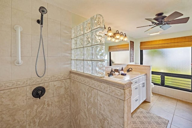 bathroom with tile patterned floors, ceiling fan, tiled shower, toilet, and vanity