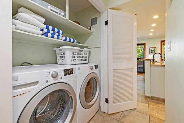 clothes washing area with sink, independent washer and dryer, and light tile patterned floors