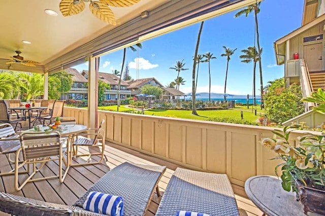 wooden terrace featuring ceiling fan and a water view