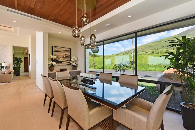 tiled dining area featuring ceiling fan, a mountain view, and wood ceiling