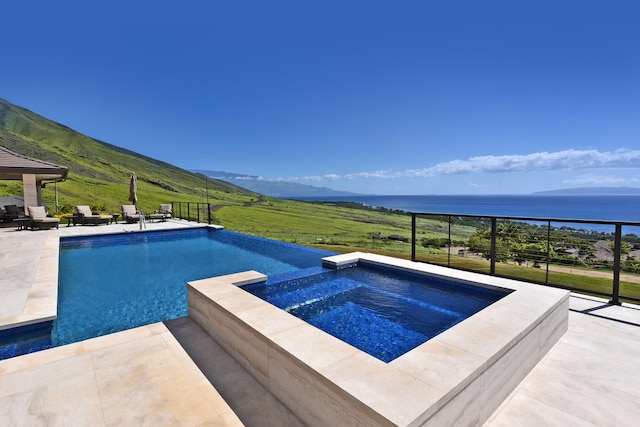 view of swimming pool featuring a patio, a water and mountain view, and an in ground hot tub