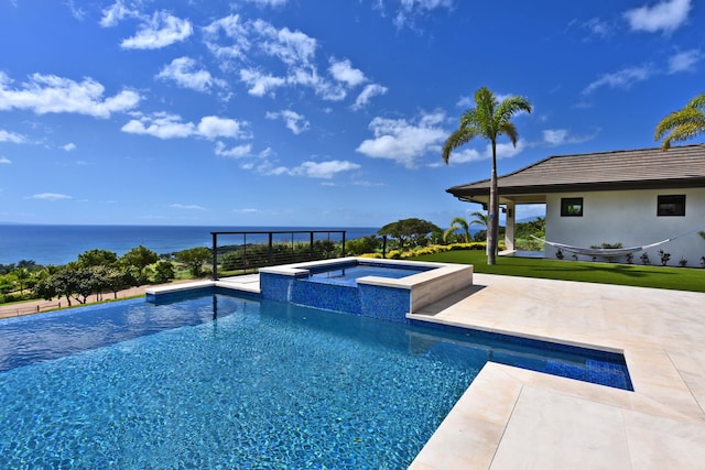 view of swimming pool featuring a lawn, a water view, an in ground hot tub, and a patio area