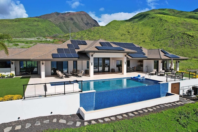 view of pool with an outdoor living space, a mountain view, and a patio area