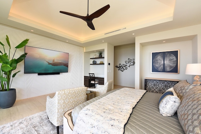 bedroom featuring a raised ceiling and ceiling fan