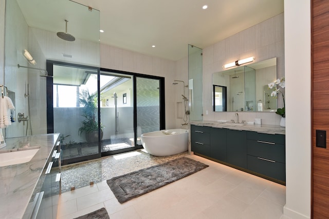 bathroom with tile patterned flooring, independent shower and bath, and vanity