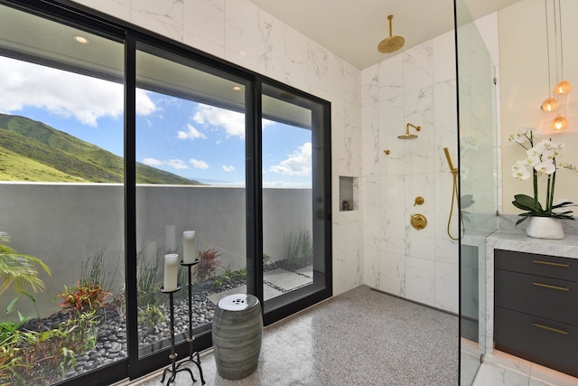 bathroom featuring a tile shower, vanity, and a mountain view