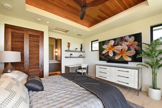 bedroom featuring wooden ceiling, connected bathroom, a tray ceiling, and ceiling fan