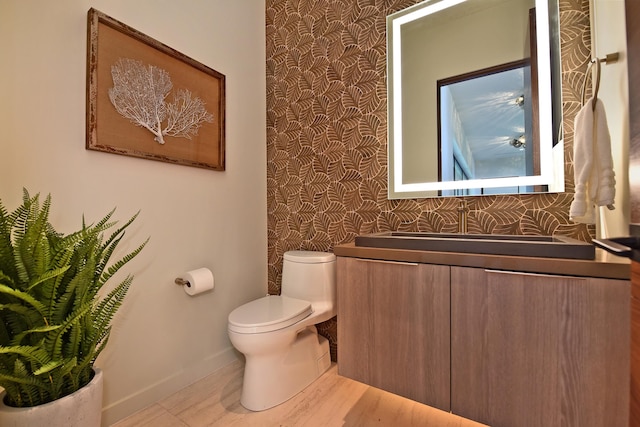 bathroom with hardwood / wood-style flooring, vanity, and toilet