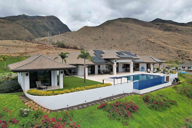 view of pool featuring a lawn, a patio, and a mountain view