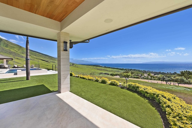 view of yard with a water view and a patio area