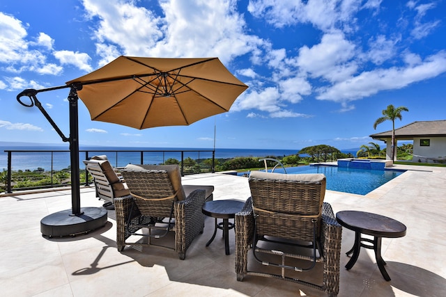 view of pool with a patio and a water view