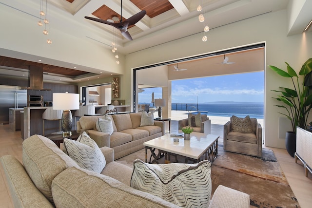 living room featuring light wood-type flooring, beam ceiling, a water view, and coffered ceiling