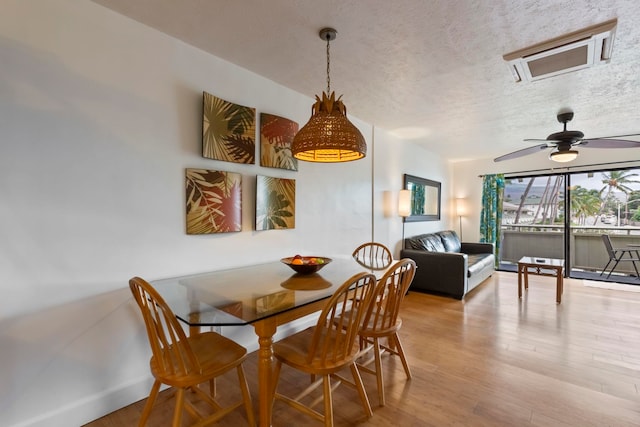 dining area featuring a textured ceiling, hardwood / wood-style flooring, and ceiling fan